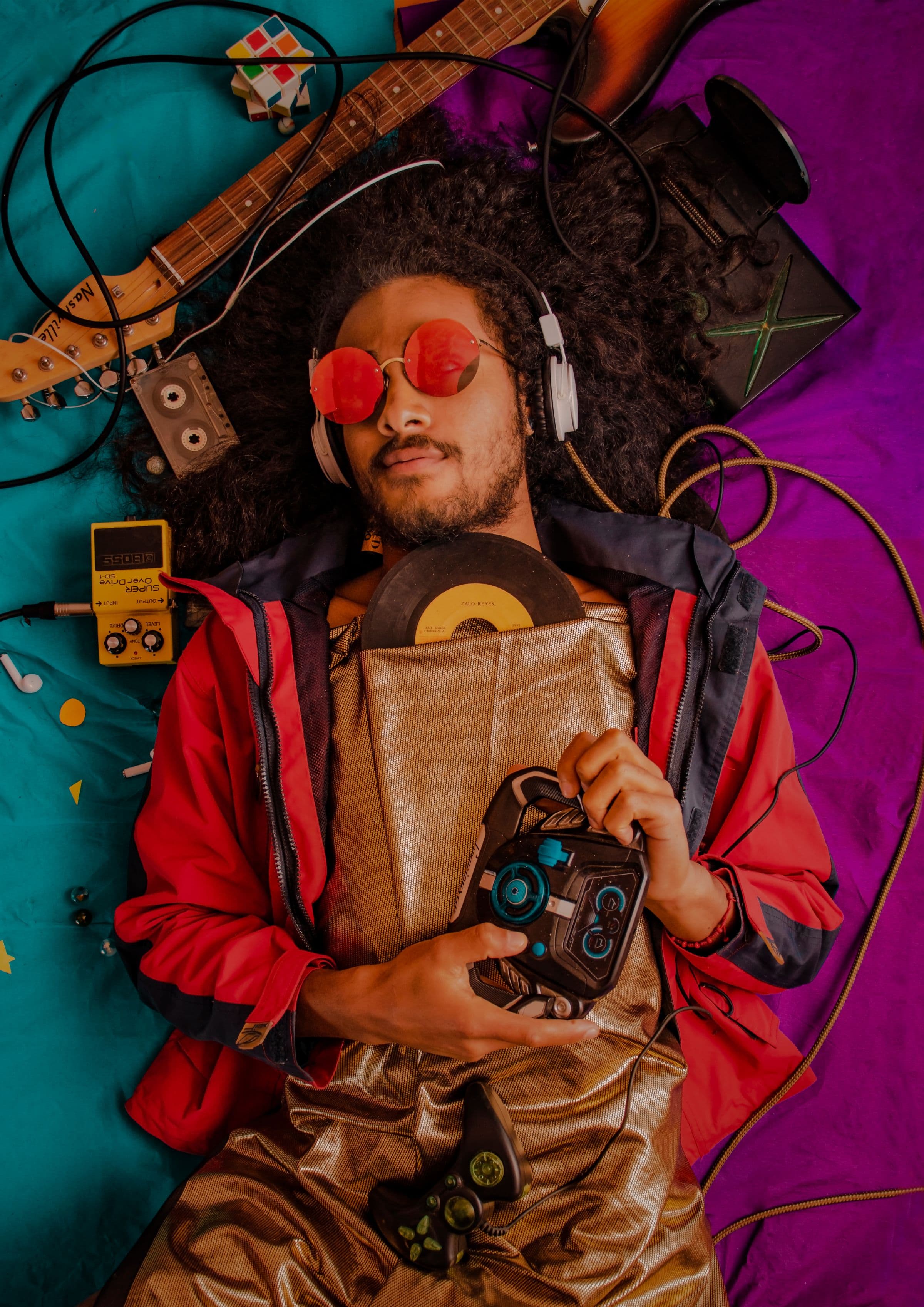 Creator with headphones surrounded by instruments, records, and a microphone
